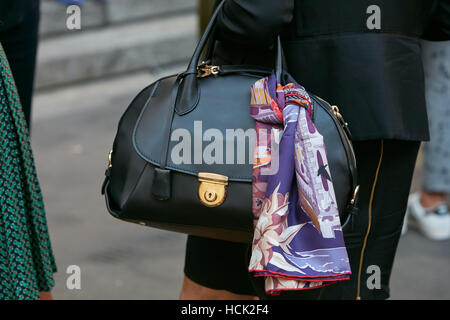 Frau mit schwarzen Salvatore Ferragamo Tasche vor Salvatore Ferragamo Modenschau, Milan Fashion Week Streetstyle am September. Stockfoto