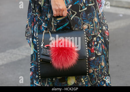 Frau mit schwarzem Ledertasche mit rotem Fell Dekoration vor Salvatore Ferragamo Modenschau, Milan Fashion Week Streetstyle. Stockfoto