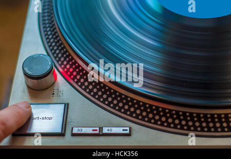 Ein Fan von HiFi-Musik beginnt den Plattenspieler zum Abspielen von vinyl Stockfoto