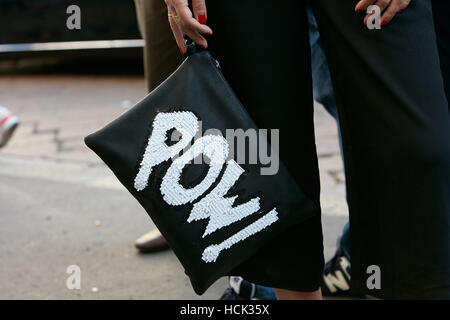 Frau mit Schwarze Ledertasche mit Pow! in weiß zu schreiben, bevor Salvatore Ferragamo Modenschau, Milan Fashion Week Streetstyle Stockfoto