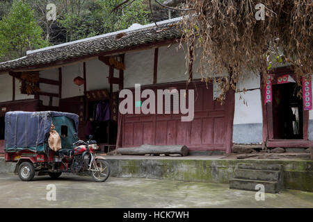 Ein Motorrad angetriebene Wagen parkten außerhalb ein traditionelles Bauernhaus in einem ländlichen Ort in Südwest-China. Stockfoto