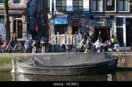 Personen auf Terrasse vor Coffeeshop Bulldog am Oudezijds Voorburgwal Kanal, Amsterdam, Niederlande Stockfoto