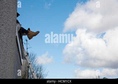 Des Erbauers Stiefel überhängenden während der Arbeit am Dach Stockfoto