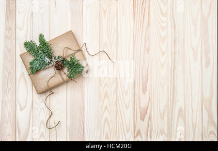 Weihnachts-Dekoration mit Handwerk Papier eingewickelt Geschenk und Kiefer Äste Stockfoto