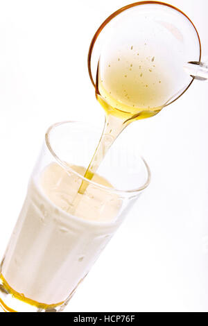 Honig in einem Glas Milch Stockfoto