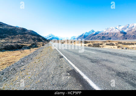 Gerade leere Autobahn, die in Aoraki Mount Cook, Neuseeland Stockfoto