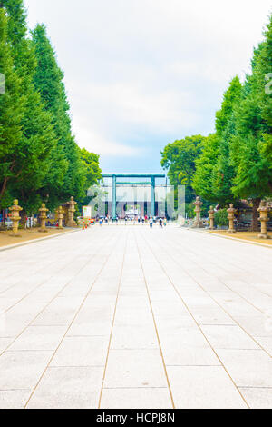 Daini Torii-Tor in der Ferne auf Baum gesäumten Pfad am Eingang zum umstrittenen Yasukuni-Schrein Shinto an einem düsteren bewölkten Tag Stockfoto