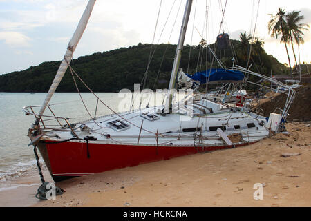 Insel Phuket, Thailand - 30. November 2014: Umgestürzter Segelboot auf Sand in Folge des Hurrikans, Segelboot nach Sturm in Panwa Beach, Insel Phuket, Stockfoto