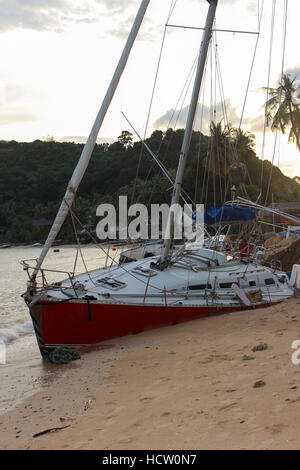 Insel Phuket, Thailand - 30. November 2014: Umgestürzter Segelboot auf Sand in Folge des Hurrikans, Segelboot nach Sturm in Panwa Beach, Insel Phuket, Stockfoto