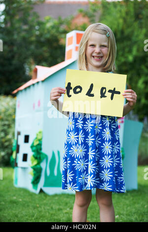 Kleines Mädchen hält Schild Spielhaus lassen Stockfoto