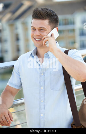 Junger Mann telefonieren mit Handy zu Fuß zur Arbeit Stockfoto