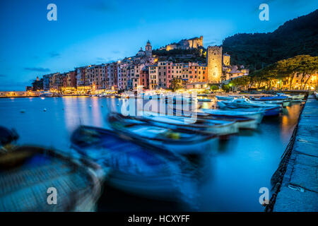 Blick auf Meer und Boote rund um das bunte Dorf in der Dämmerung, Portovenere, UNESCO, La Spezia Provinz, Ligurien, Italien Stockfoto