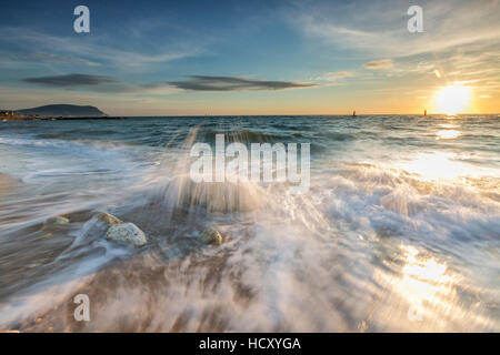 Wellen an den Sandstrand, eingerahmt von Sonnenaufgang, Porto Recanati, Provinz Macerata, Conero Riviera, Marche, Italien Stockfoto