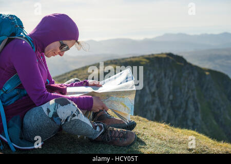 Überprüfen einer Map auf dem Weg nach unten von Lakelandpoeten in Richtung Grisedale Tarn, Nationalpark Lake District, Cumbria, UK Stockfoto