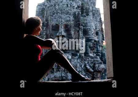 Ein Tourist schaut aus einer der Türen am Bayon Tempel in Angkor, UNESCO, Siem Reap, Kambodscha, Indochina Stockfoto