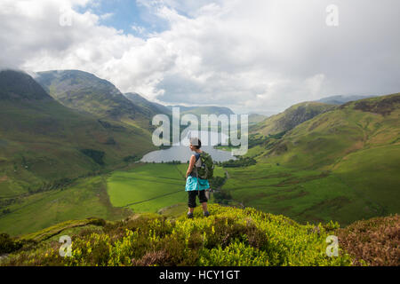 Eine Frau blickt Buttermere aus Fleetwith Pike, Nationalpark Lake District, Cumbria, UK Stockfoto