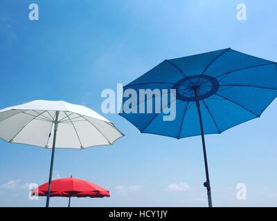 Rot, weiß und blau Strand Sonnenschirme vor blauem Himmel, Alpes Maritimes, Cote d ' Azur, Côte d ' Azur, Provence, Nizza, Frankreich Stockfoto