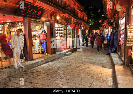 Lijiang, China - 10. November 2016: Panoramablick auf eine der Straßen in der Altstadt von Lijiang bei Sonnenuntergang mit einigen Touristen vorbei Stockfoto