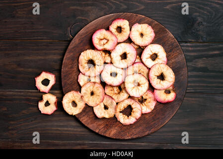 Äpfel-Chips auf Holzbrett, Ansicht von oben Stockfoto