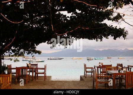 Ein Blick auf das Meer, Boote und Lombok von einem Strandrestaurant auf Gili Trawangan Stockfoto