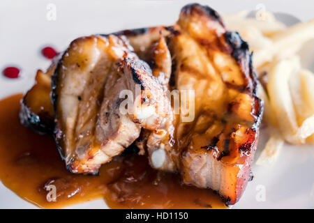 Spanisch Spareribs, entbeint und mit roten Honig Dip und Pommes frites als Beilage serviert. Stockfoto