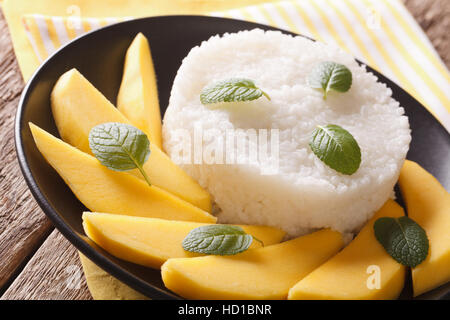 Thai Sweet Klebreis mit Mango-close-up auf einem schwarzen Teller auf den Tisch. Horizontale Stockfoto