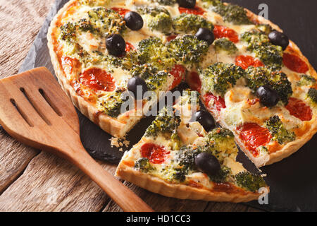 Leckere Tarte mit Hähnchen, Brokkoli, Tomaten und Oliven Nahaufnahme auf dem Tisch. Horizontale Stockfoto