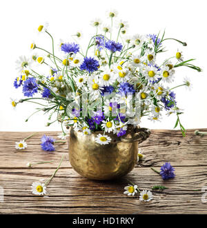 Bouquet von Kamillen und Kornblumen in der Vase auf dem Holztisch. Weißen Hintergrund. Stockfoto