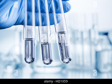 Labor-Becher in der Hand des Analytikers in Plastikhandschuhe. Stockfoto