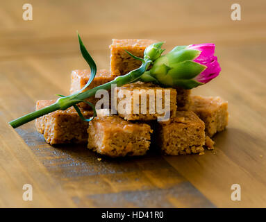 Pfannkuchen mit einer roten Distel auf einen Eichentisch gekrönt, Stockfoto