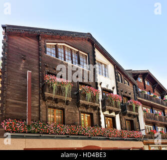 Zermatt, Schweiz - 24. August 2016: Traditionelle Schweizer Chalets mit Blumen auf dem Balkon im Ferienort Zermatt in der Schweiz im Sommer Stockfoto