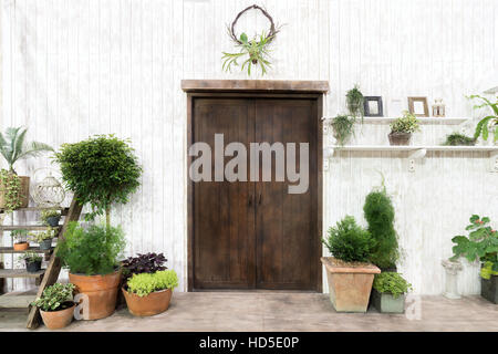 Vordere Holztür und Gartendekor in weiß gemütliches Haus oder Häuschen. Außenseite des Hauses. Stockfoto