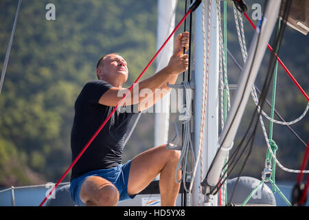 Segler zieht das Seil, das Segel Segelboot zu kontrollieren. Stockfoto