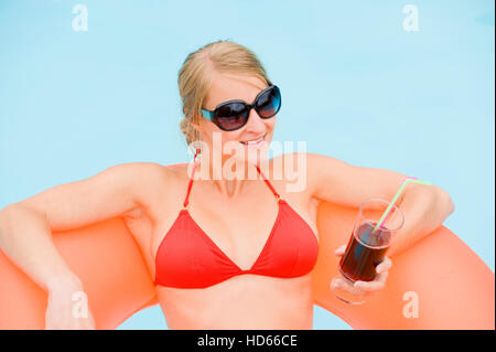 Junge, attraktive Frau, trinken einen Cocktail in einem Schwimmbad Stockfoto