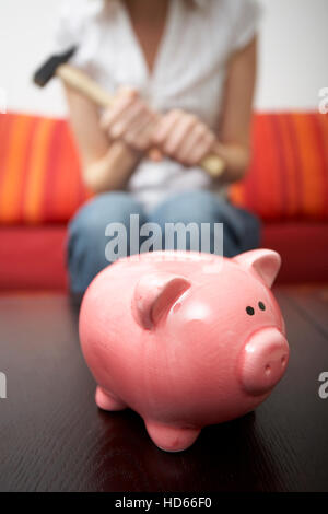 Sparschwein, Frau mit einem hammer Stockfoto