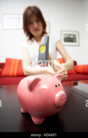 Sparschwein, Frau mit einem hammer Stockfoto