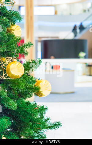 Weihnachtsbaum mit Golddekoration im Einkaufszentrum. Weihnachten-Abverkäufe in der Shopping Mall. Stockfoto