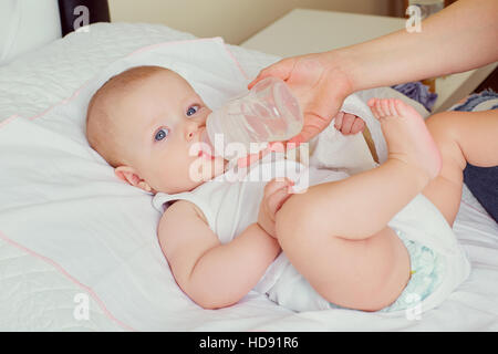 Mutter mit der Flasche füttern ihr Baby. Die Pflege, die Erziehung der Kinder Stockfoto