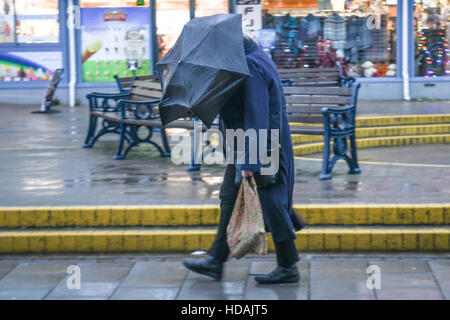 Aberystwyth Wales UK, Samstag, 10. Dezember 2016 UK Wetter: ein Mann kämpft mit seinem Regenschirm auf einem grauen, trüben nassen und windigen Ausklang des Tages in Aberystwyth auf West Wales Küste Photo Credit: Keith Morris / Alamy Live News Stockfoto