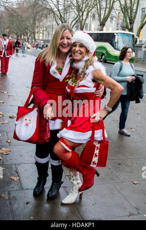 Zwei weibliche Santacon Santas auf den Straßen von London. Santacon ist eine nicht-religiöse Weihnachtsparade, die normalerweise jeden Dezember an einem Samstag in London stattfindet. Stockfoto