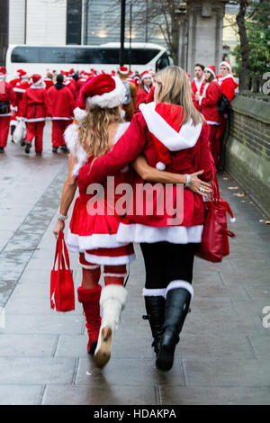 Zwei weibliche Santacon Santas auf den Straßen von London. Santacon ist eine nicht-religiöse Weihnachtsparade, die normalerweise jeden Dezember an einem Samstag in London stattfindet. Stockfoto