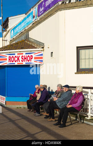 Bournemouth, Dorset, UK 11. Dezember 2016. Rentner sitzen auf Bank durch den Rock Shop am Eingang zum Bournemouth Pier an einem schönen sonnigen Tag im Dezember.  Bildnachweis: Carolyn Jenkins/Alamy Live-Nachrichten Stockfoto