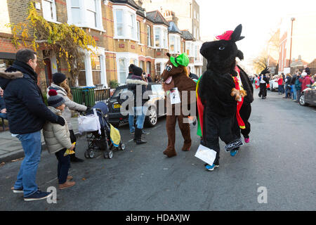 Greenwich, London, UK. 11. Dezember 2016. Menschen verkleidet als kostümierte Pantomime Pferde in der jährlichen London Pantomime Pferderennen in Greenwich, Süd-Ost-London statt teilnehmen. Die Komödie-Rennen findet statt durch die Straßen von Greenwich, mit der "Rennpferde" einander bis zur Ziellinie, Halt an verschiedenen Kneipen und Boxenstopps wie sie für verschiedene Wohltätigkeitsorganisationen zu Weihnachten Geld. Bildnachweis: Vickie Flores/Alamy Live-Nachrichten Stockfoto