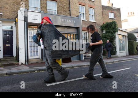 Greenwich, London, UK. 11. Dezember 2016. Menschen verkleidet als kostümierte Pantomime Pferde in der jährlichen London Pantomime Pferderennen in Greenwich, Süd-Ost-London statt teilnehmen. Die Komödie-Rennen findet statt durch die Straßen von Greenwich, mit der "Rennpferde" einander bis zur Ziellinie, Halt an verschiedenen Kneipen und Boxenstopps wie sie für verschiedene Wohltätigkeitsorganisationen zu Weihnachten Geld. Bildnachweis: Vickie Flores/Alamy Live-Nachrichten Stockfoto