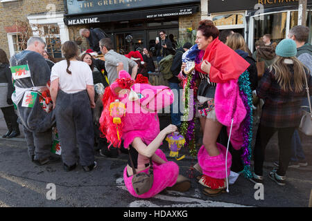 Greenwich, London, UK. 11. Dezember 2016. Menschen verkleidet als kostümierte Pantomime Pferde in der jährlichen London Pantomime Pferderennen in Greenwich, Süd-Ost-London statt teilnehmen. Die Komödie-Rennen findet statt durch die Straßen von Greenwich, mit der "Rennpferde" einander bis zur Ziellinie, Halt an verschiedenen Kneipen und Boxenstopps wie sie für verschiedene Wohltätigkeitsorganisationen zu Weihnachten Geld. Bildnachweis: Vickie Flores/Alamy Live-Nachrichten Stockfoto