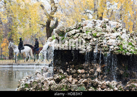 Brunnen im Parque del Retiro in Madrid, Spanien mit zwei Polizei Pferd vorbei. Stockfoto