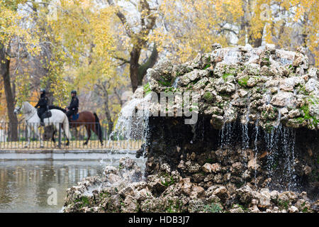 Brunnen im Parque del Retiro in Madrid, Spanien mit zwei Polizei Pferd vorbei. Stockfoto