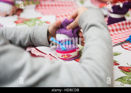 Glückliches Kind Handwerk zu tun. Kleines Kind einen Filzen Weihnachten Schneemann in Händen hält. Arbeitsplatz in Kindergarten, Schule oder zu Hause. Kinder Weihnachten basteln Idee. Stockfoto