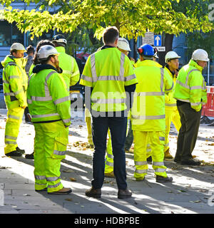 Gruppe von Menschen Schutzhelm Männer stehen zu Beginn des Geschäftstreffens herum und tragen Warnkleidung großes Straßenbauprojekt London England UK Stockfoto