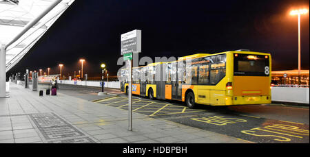 Vor dem Flughafenterminal, Hotelbus des Stansted Airport, Nachtbus zum Pendelverkehr zu den Außenparkplätzen, ruhiger, früher, kalter Wintermorgen in Essex England Stockfoto